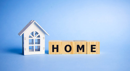 Stock word home spelled on alphabet wooden block letters on old weathered wood blocks over blue, home concept