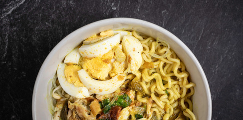 soto ayam is traditional food from indonesia, served with chicken, noodles, egg, sambal and fried onions