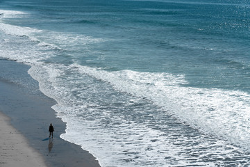 A woman walking alone on beach