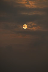 MORNING SUN SHINING BEHIND THE CLOUDS