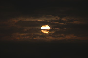 MORNING SUN SHINING BEHIND THE CLOUDS