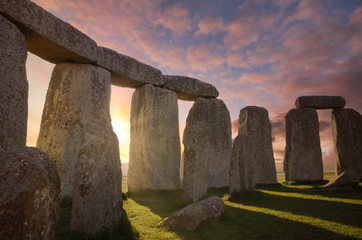 Inside the Stonehenge Circle of Stones with a Sun Rays Filtering Through the ArchesDramatic Sky Sunrise behind it