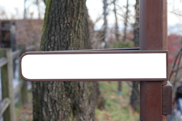 Empty white street sign on the metal pole.