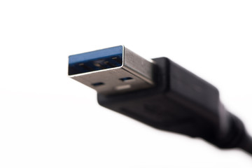 USB cable connector with blurred cable close up on white background