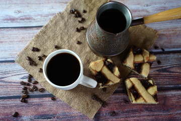 A Cup of coffee, pieces of homemade cake and Turkish coffee pot on the table
