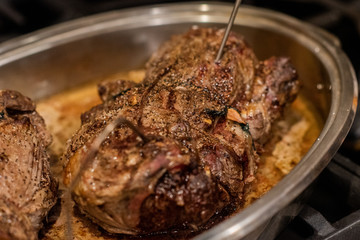 A freshly cooked meat resting on a stove