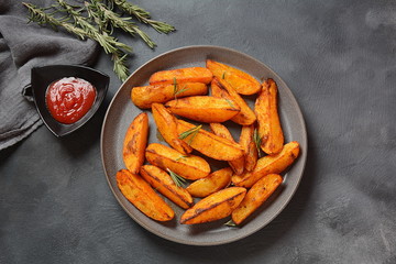 Baked, fried potato wedges with spices and rosemary. Roast potatoes with spices in the frying pan