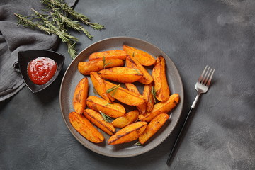 Baked, fried potato wedges with spices and rosemary. Roast potatoes with spices in the frying pan
