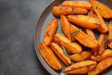 Baked, fried potato wedges with spices and rosemary. Roast potatoes with spices in the frying pan