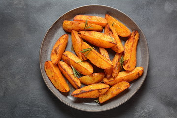 Baked, fried potato wedges with spices and rosemary. Roast potatoes with spices in the frying pan