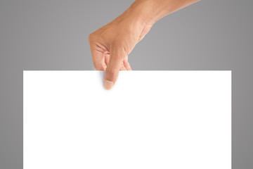 hand holding blank sheet of white paper isolated on gray with copy space for text and picture