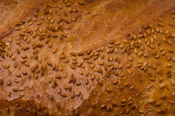 tasty sesame seeds are sprinkled on a bun baked bread close up