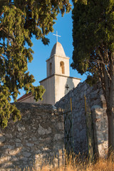 Fototapeta na wymiar the church is buried in verdure against the blue sky