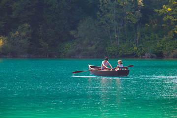 Fototapeta na wymiar man and woman on a boat sailing in a blue lake