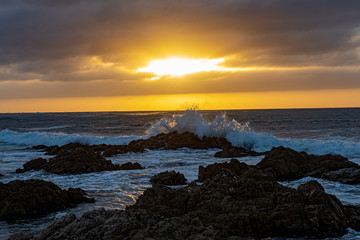 Obraz premium A brilliant sunset illuminates the rough surf