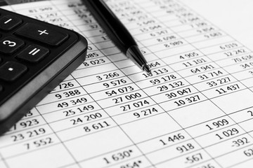 Financial concept. Calculator, pen and glasses on financial documents. Financial accounting. Balance sheets. Closeup of financial statements and annual reports. Business marketing