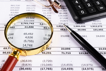 Financial concept. Calculator, pen and glasses on financial documents. Financial accounting. Balance sheets. Closeup of financial statements and annual reports. Business marketing