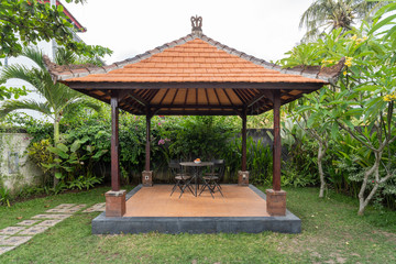 Open gazebo with chairs and table on backyard