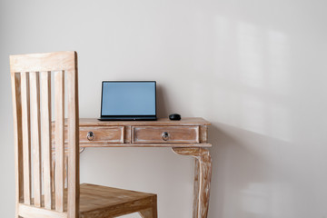 Laptop computer on wooden table in room
