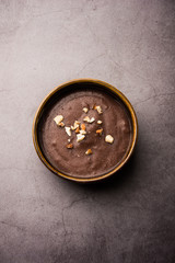 Sweet Ragi Malt / Healthy Ragi Porridge in a bowl garnished with crushed dry fruits