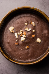 Sweet Ragi Malt / Healthy Ragi Porridge in a bowl garnished with crushed dry fruits