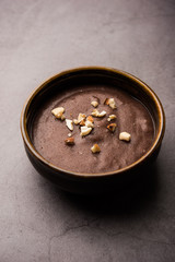 Sweet Ragi Malt / Healthy Ragi Porridge in a bowl garnished with crushed dry fruits