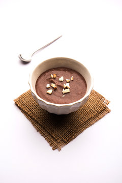 Sweet Ragi Malt / Healthy Ragi Porridge in a bowl garnished with crushed dry fruits