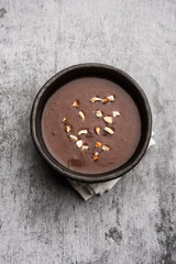Sweet Ragi Malt / Healthy Ragi Porridge in a bowl garnished with crushed dry fruits