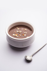 Sweet Ragi Malt / Healthy Ragi Porridge in a bowl garnished with crushed dry fruits