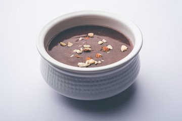 Sweet Ragi Malt / Healthy Ragi Porridge in a bowl garnished with crushed dry fruits