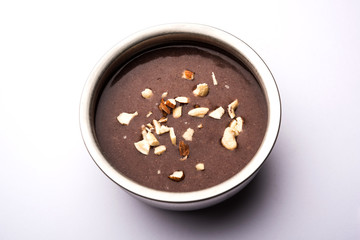 Sweet Ragi Malt / Healthy Ragi Porridge in a bowl garnished with crushed dry fruits