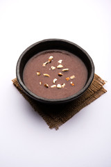 Sweet Ragi Malt / Healthy Ragi Porridge in a bowl garnished with crushed dry fruits