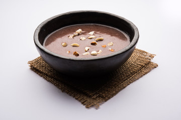 Sweet Ragi Malt / Healthy Ragi Porridge in a bowl garnished with crushed dry fruits