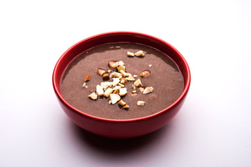 Sweet Ragi Malt / Healthy Ragi Porridge in a bowl garnished with crushed dry fruits