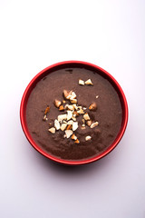 Sweet Ragi Malt / Healthy Ragi Porridge in a bowl garnished with crushed dry fruits
