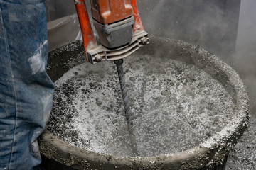 Man kneads cement mortar with a mixer. Floor screed is processed in the apartment. The worker performs a sand-cement floor screed.