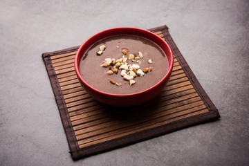 Sweet Ragi Malt / Healthy Ragi Porridge in a bowl garnished with crushed dry fruits