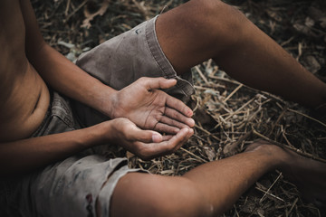hands poor child or beggar begging you for help sitting at dirty slum. concept for poverty or...