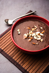 Sweet Ragi Malt / Healthy Ragi Porridge in a bowl garnished with crushed dry fruits