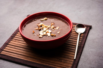 Sweet Ragi Malt / Healthy Ragi Porridge in a bowl garnished with crushed dry fruits