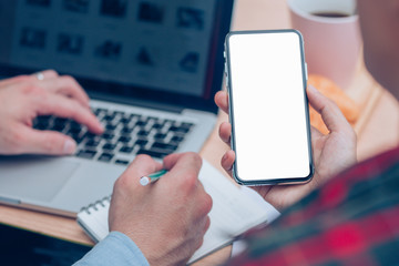 Mockup image blank white screen cell phone.man hand holding texting using mobile on desk at home office.background empty space for advertise text.people contact marketing business,technology 
