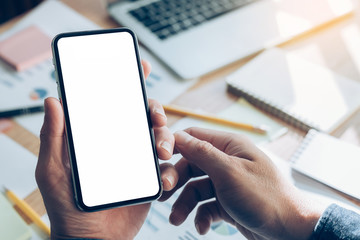 Mockup image blank white screen cell phone.man hand holding texting using mobile on desk at home office.background empty space for advertise text.people contact marketing business,technology 