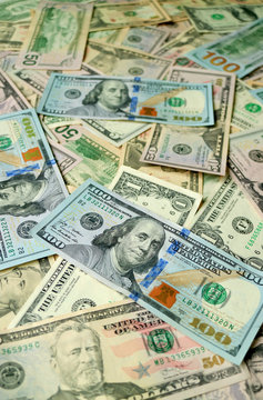Vertical image of uncountable United States dollar banknotes with selective focus