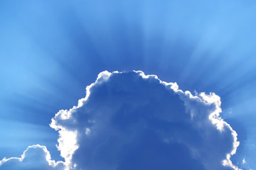Stunning blue grey cumulus cloud with sunbeams in the backdrop