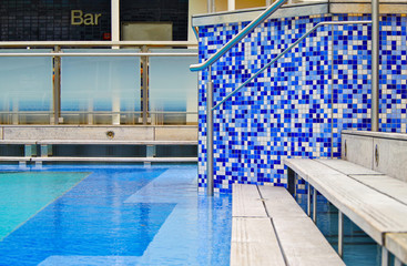 Detail close up of side of swimming pool aboard Celebrity Cruises luxury cruise ship liner with bar...
