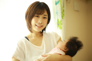 眠る赤ちゃんを抱く母親