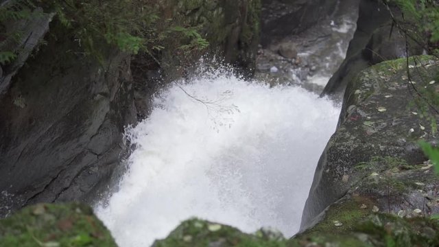 On top of a waterfall looking at the water go down in the forrest.