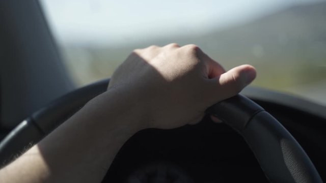 This was taken at a higher frame rate and has been converted to a slow motion video clip.  Smooth footage in a car and it is a close up of a hand on a car wheel driving.