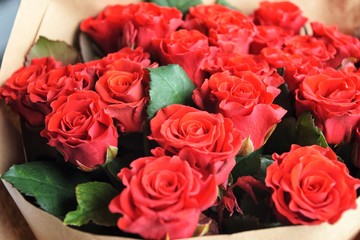 Red roses background. beautiful lush lava roses with selective focus in craft paper. St valentines bouquet made of amazing red roses. Bouquet of red roses. Present for Mother’s Day. St Valentine’s Day