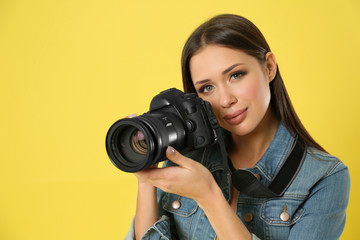 Professional photographer working on yellow background in studio